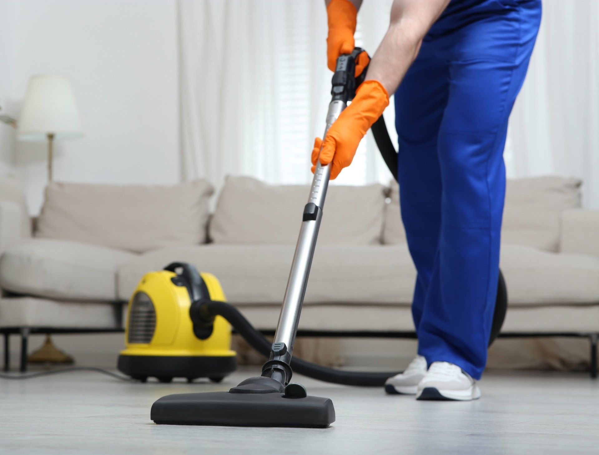 A person is using a vacuum cleaner in a living room.