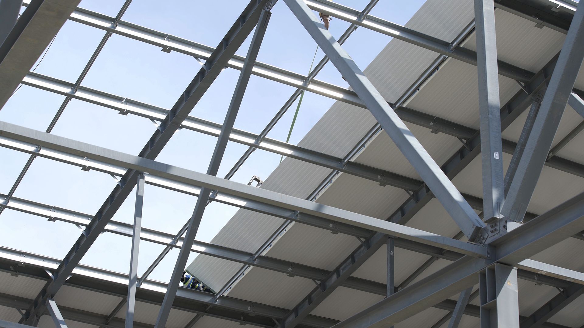 Looking up at a metal structure with a blue sky in the background