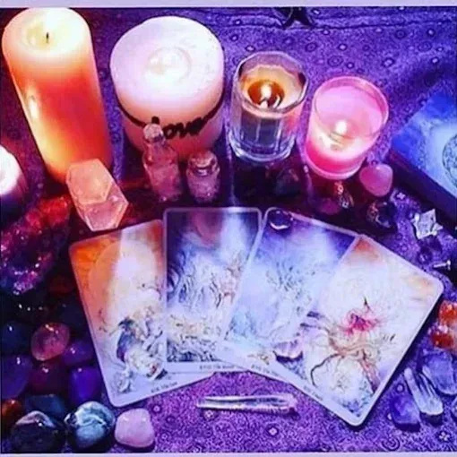 A deck of tarot cards is sitting on a table next to candles.
