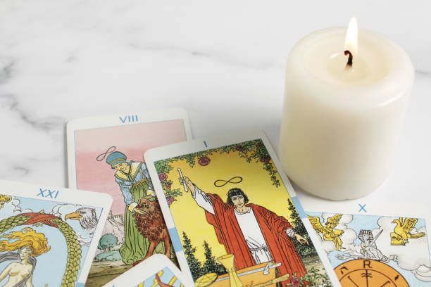 Tarot cards and a candle on a table.