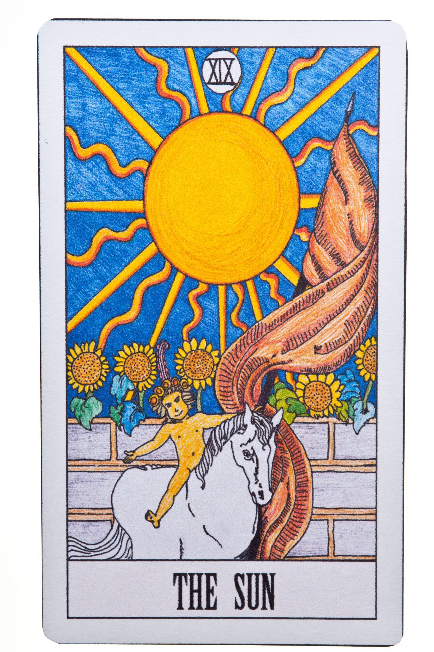 A stack of blue tarot cards next to a candle on a blue cloth.