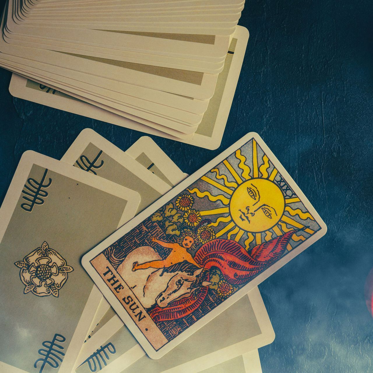 The sun tarot card is surrounded by other tarot cards