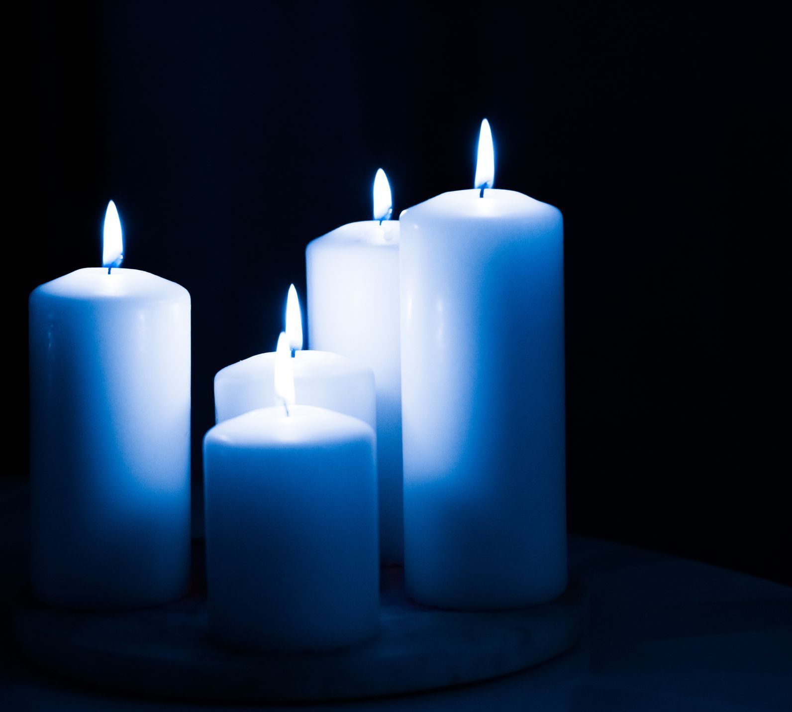 A purple candle is lit next to a bunch of playing cards
