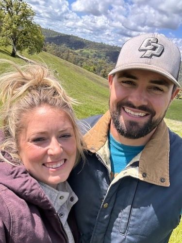 Black wine tote bag with the Terre Rouge Artisan Wines logo, holding bottles. Wooden background.