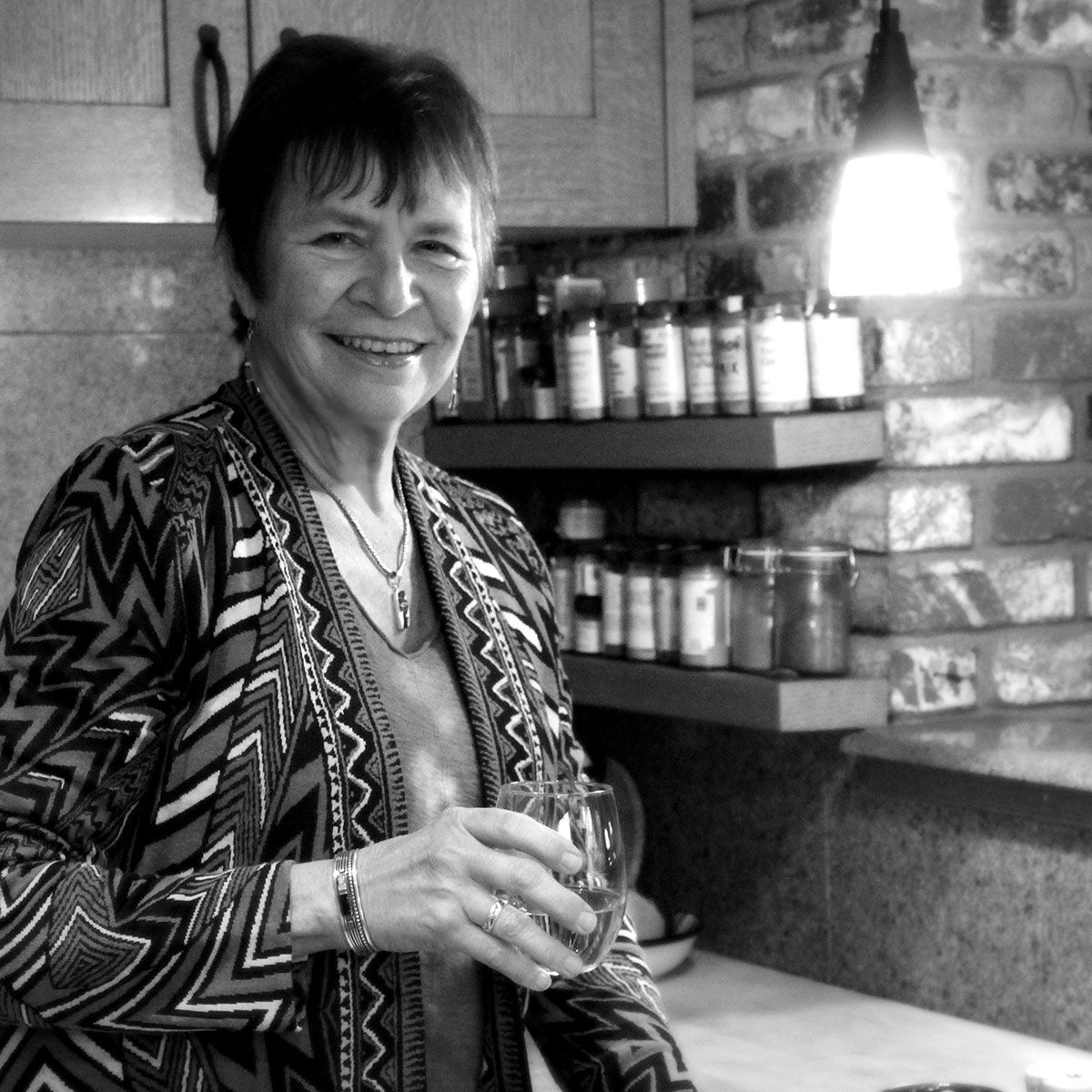 A black and white photo of a woman holding a glass