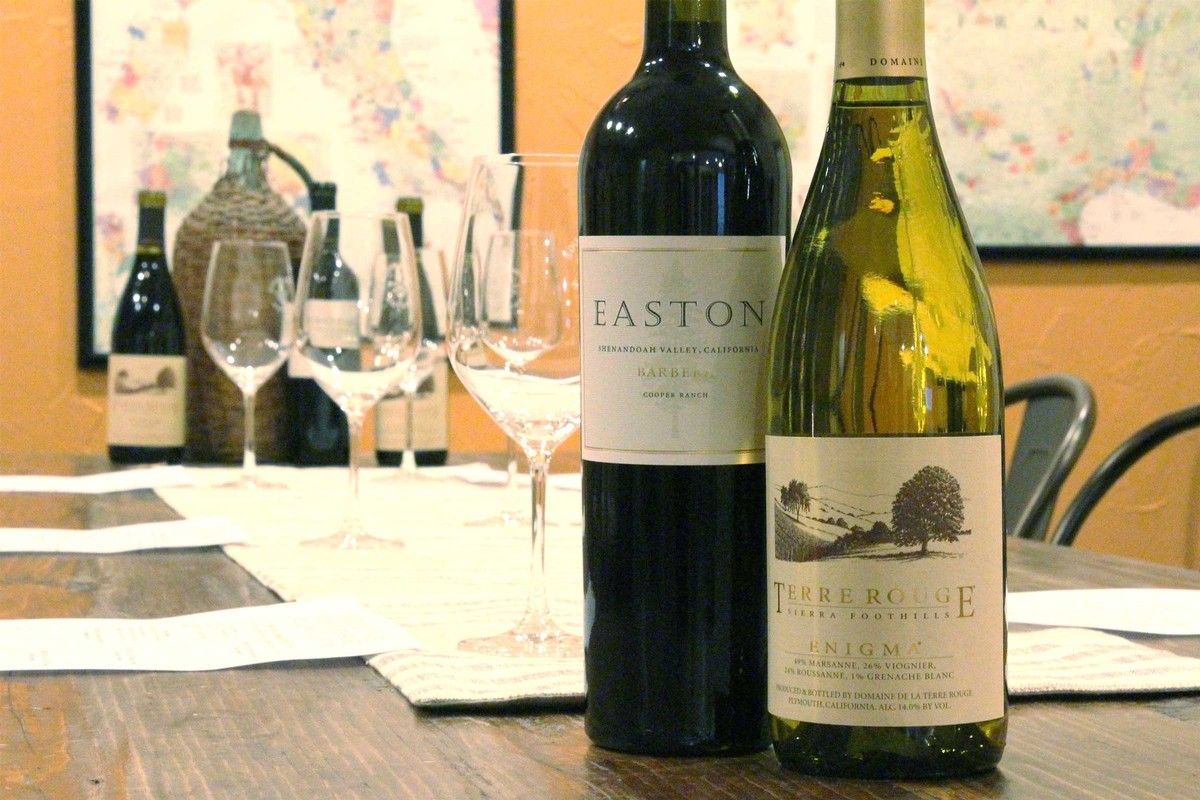 Two bottles of wine are sitting on a wooden table.