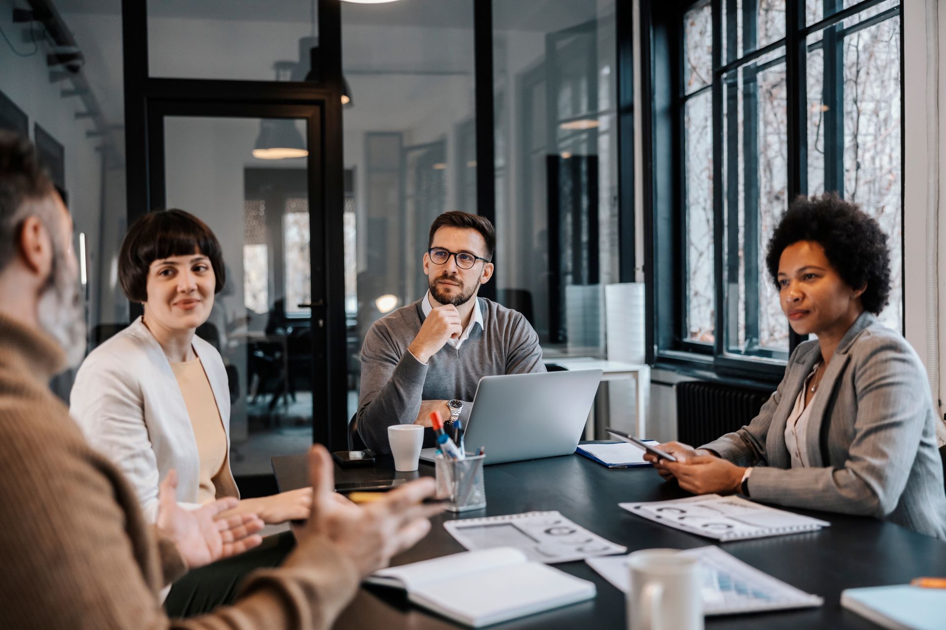A group of people are sitting around a table having a meeting.