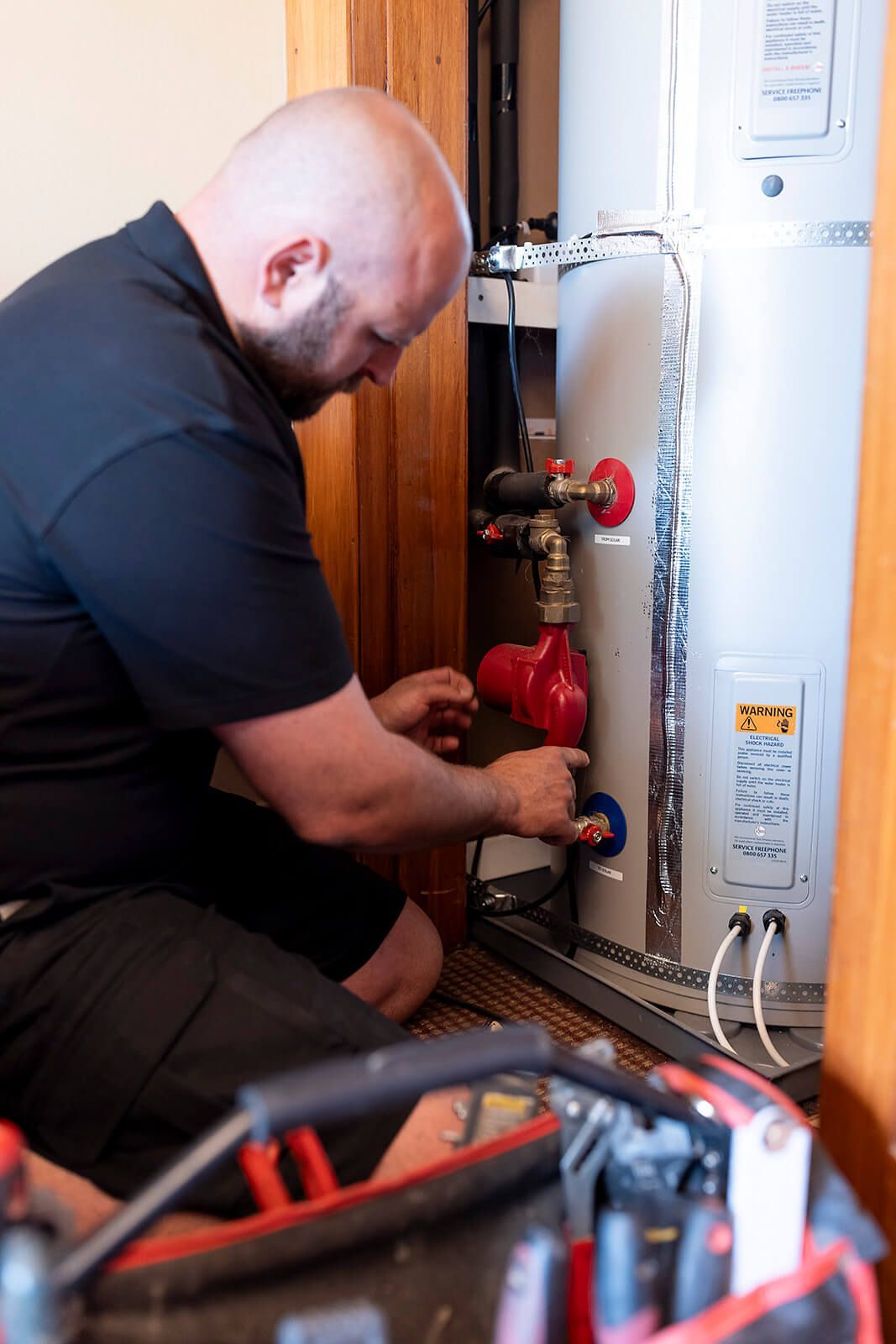 A stainless steel water heater with a copper pipe attached to it