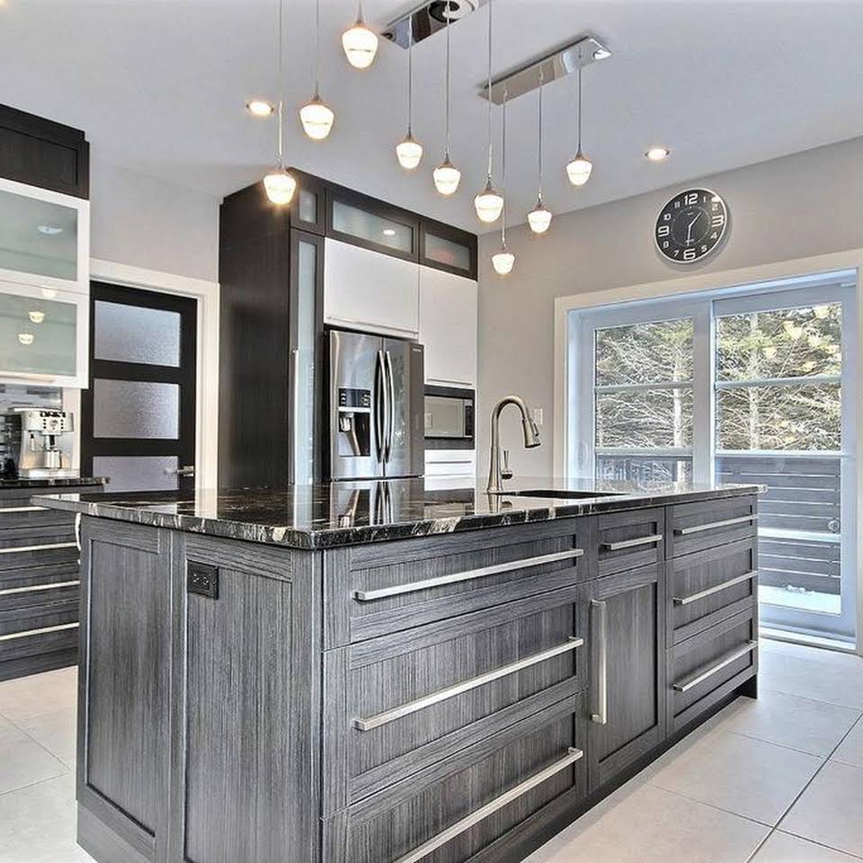 Une cuisine avec un grand îlot et une horloge au mur