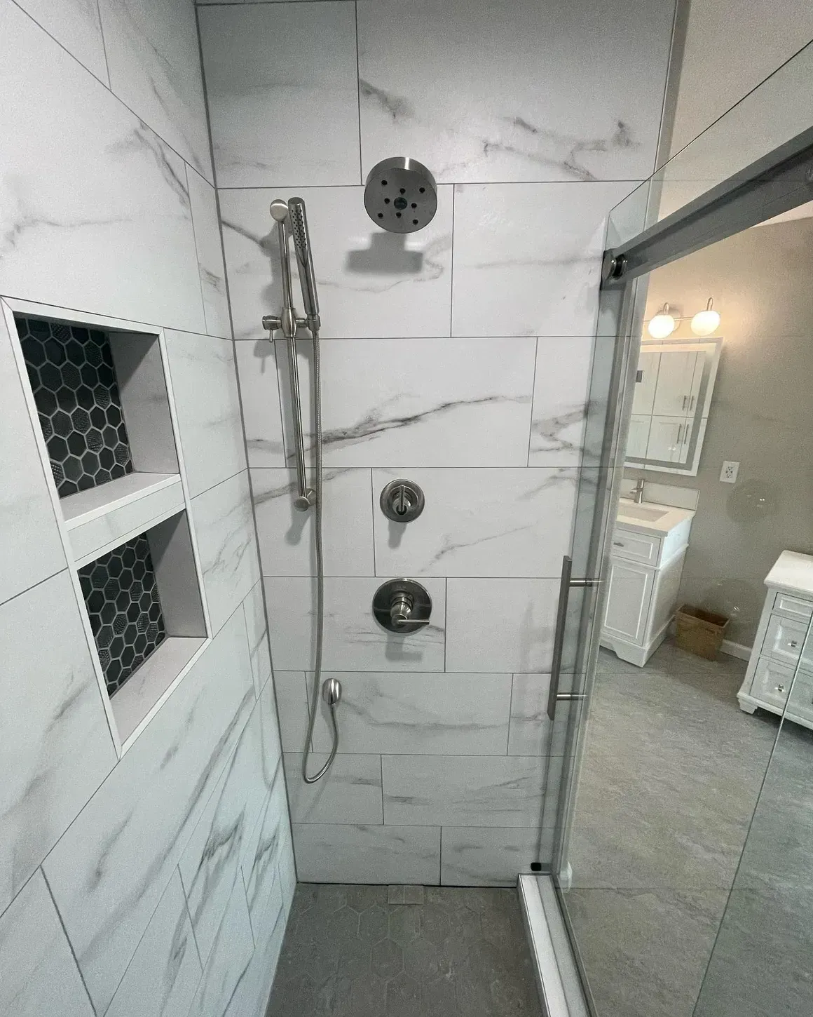 A bathroom with a walk in shower and a sink.