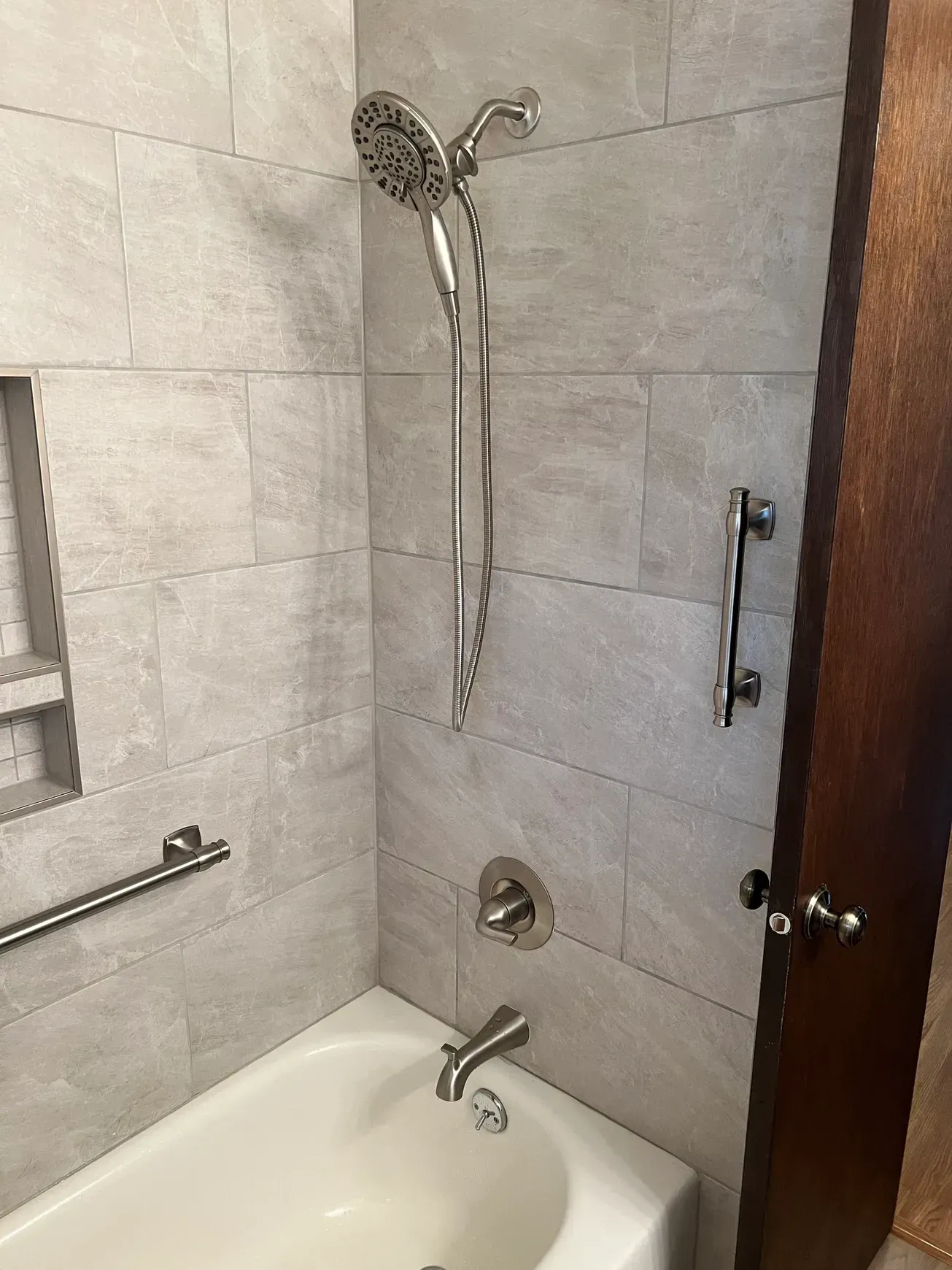A bathroom with a bathtub and a shower head.
