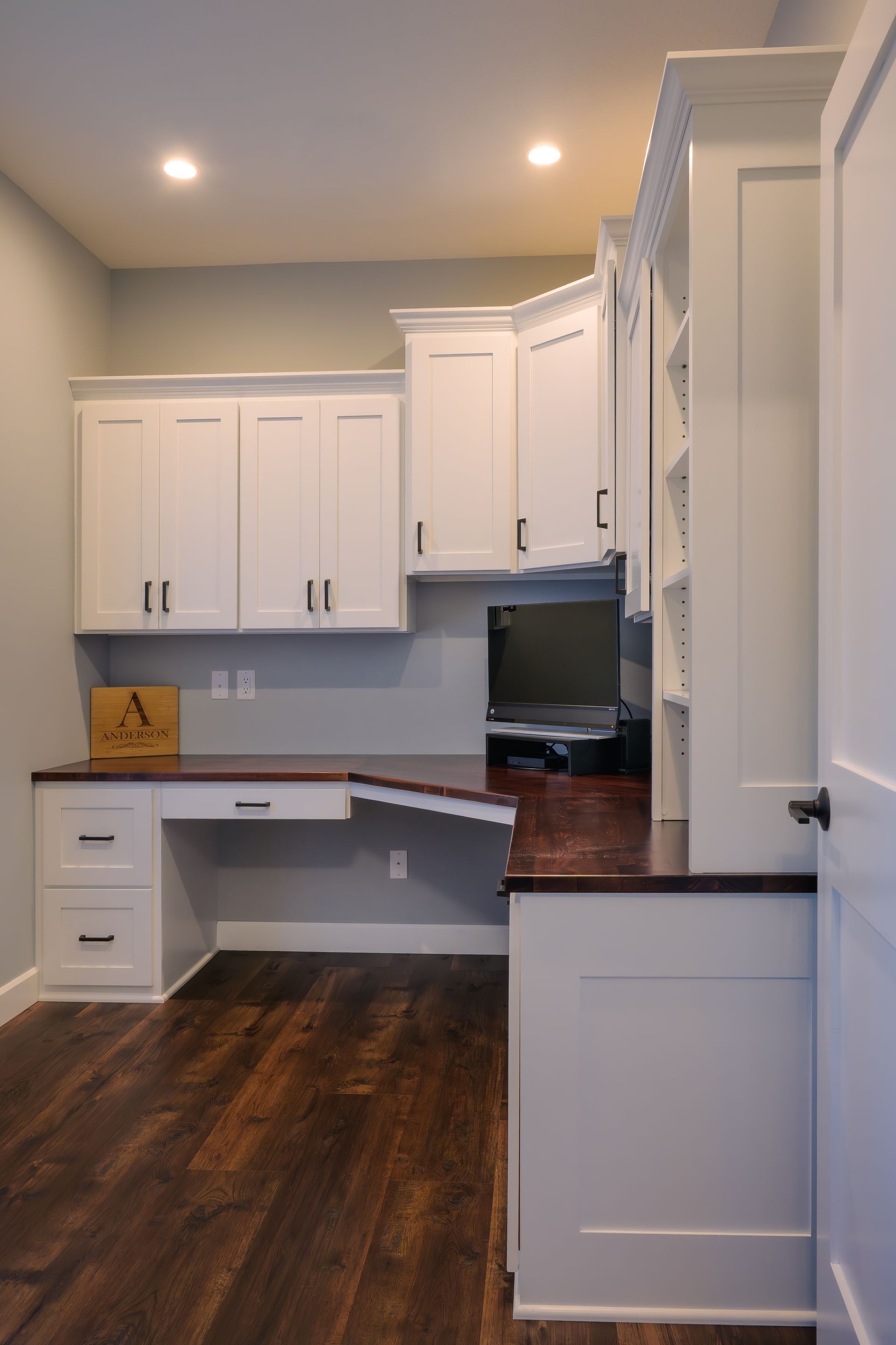 Custom white painted wood office with adjustable shelves and stained wood top.
