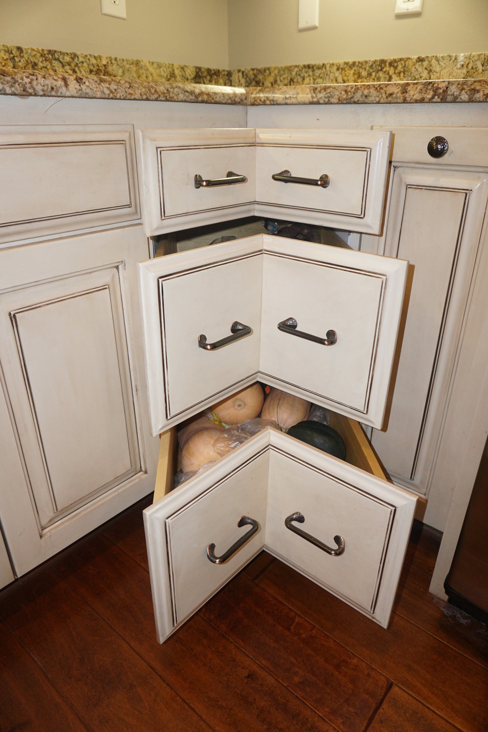 Custom white glazed wood kitchen cabinet with corner drawer.