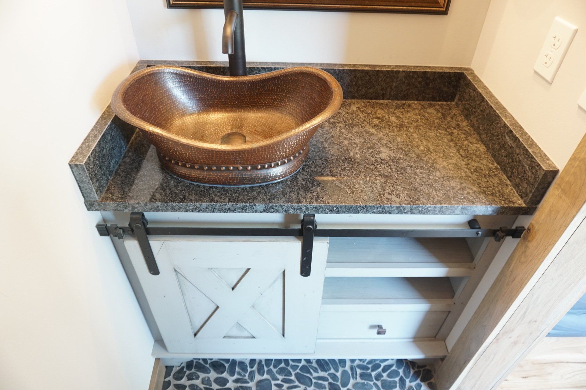 Custom bathroom vanity with X sliding barn doors and copper sink.