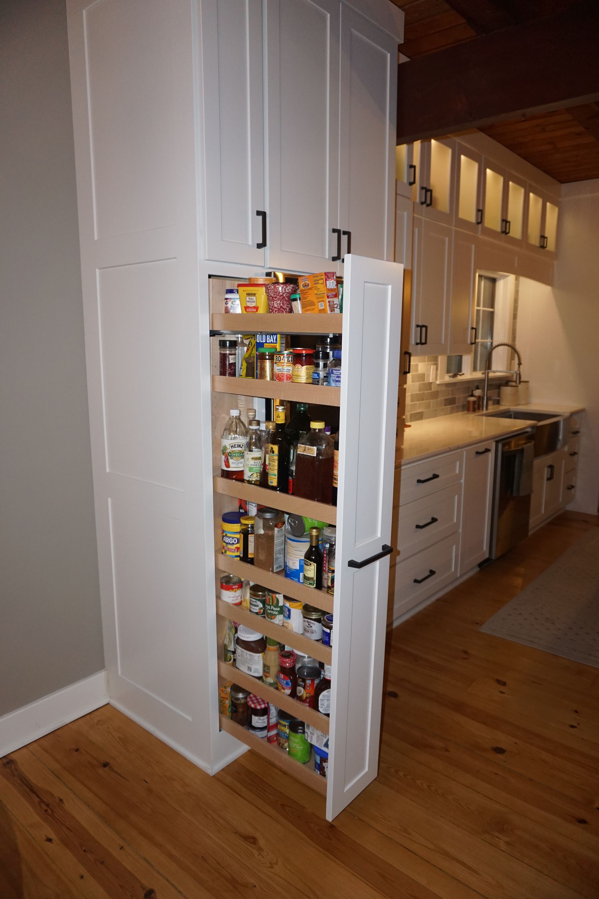 Custom full height vertical kitchen pantry pullout storage solution.