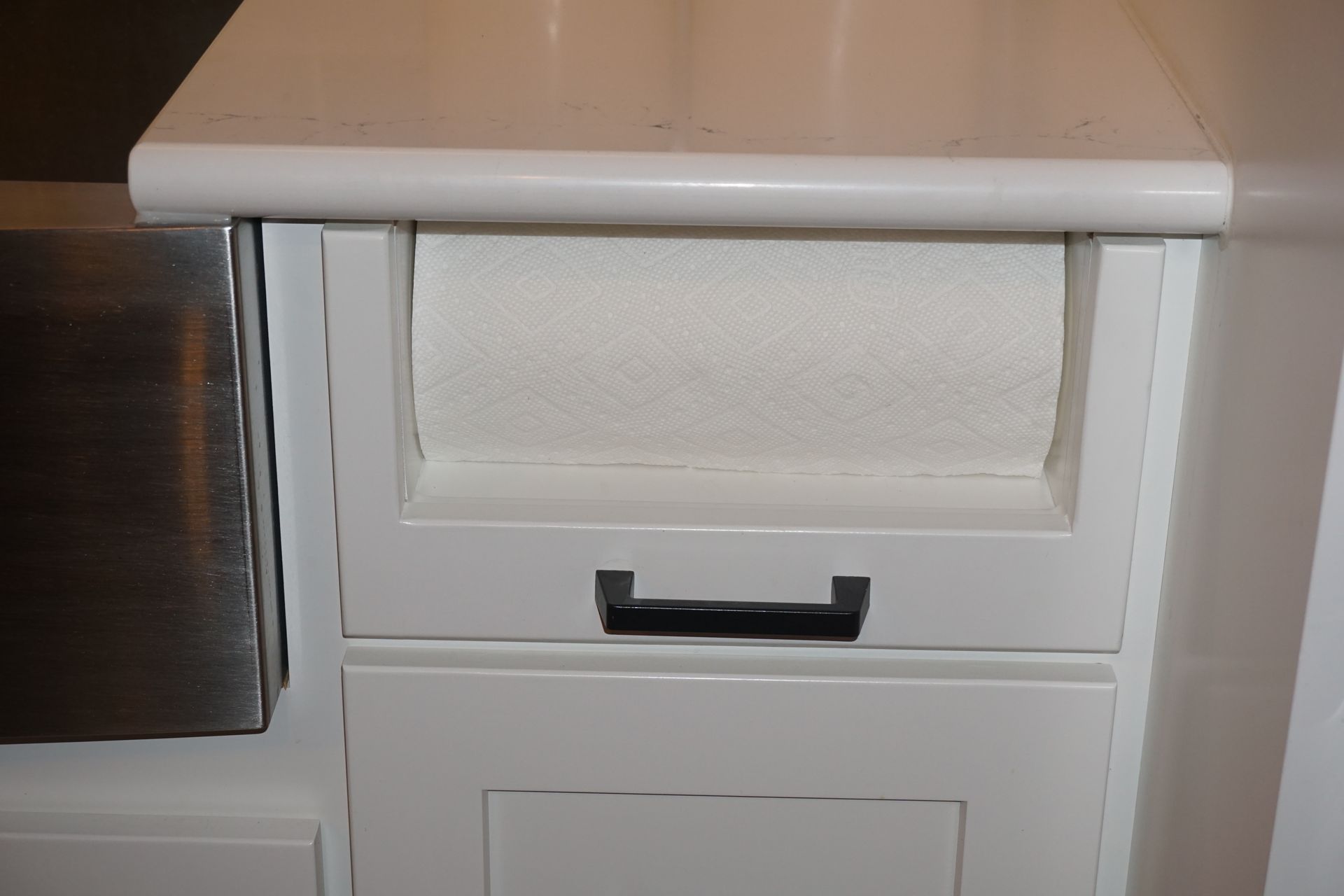 Kitchen under countertop paper towel holder and dispenser.
