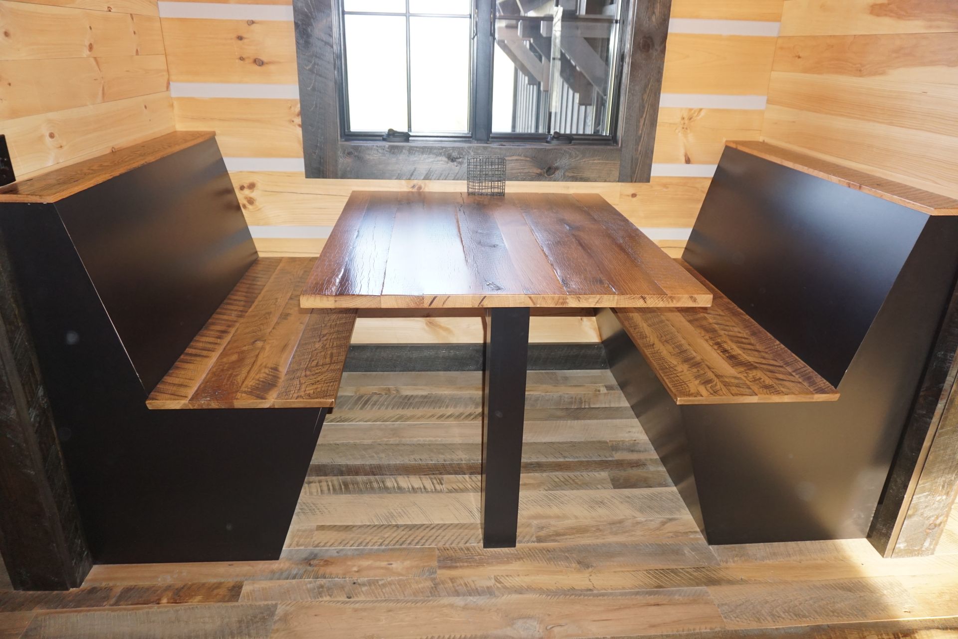 Custom black painted wood dining room seating and table with stained wood top.