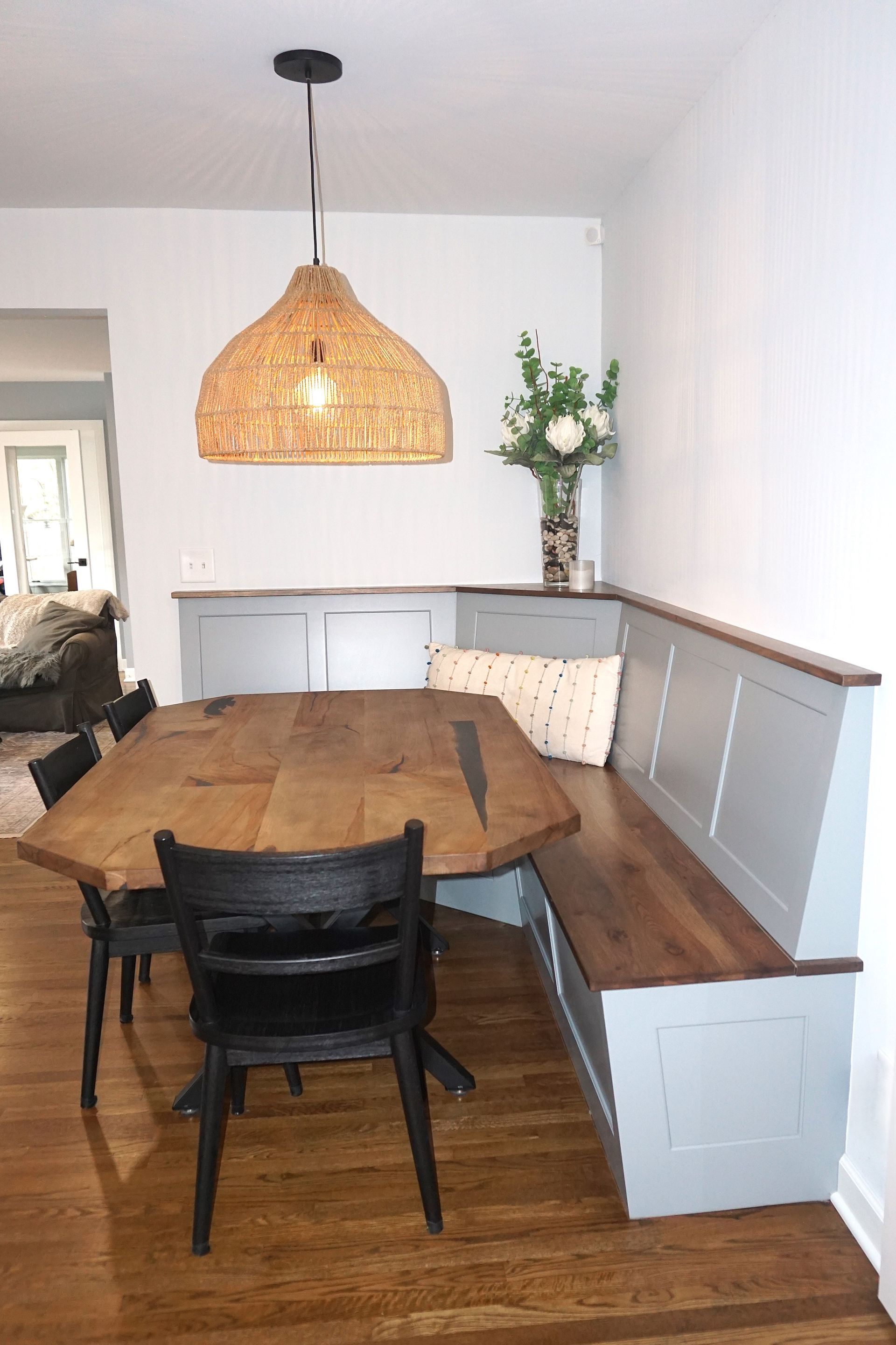 Custom white painted wood bench seat with stained top for dining room with Asian style pendant light.