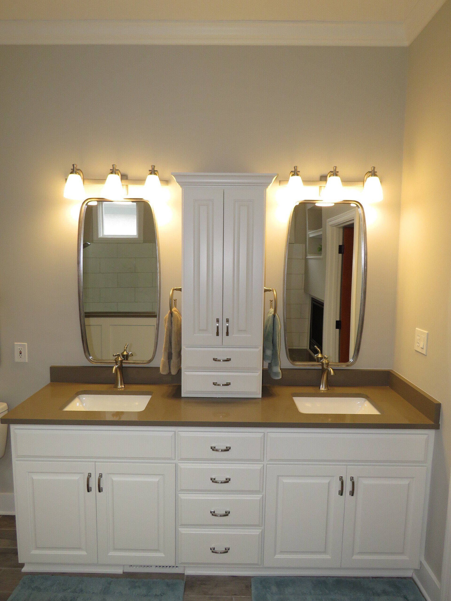 Custom white painted double bathroom vanity with tower and unique lighting.