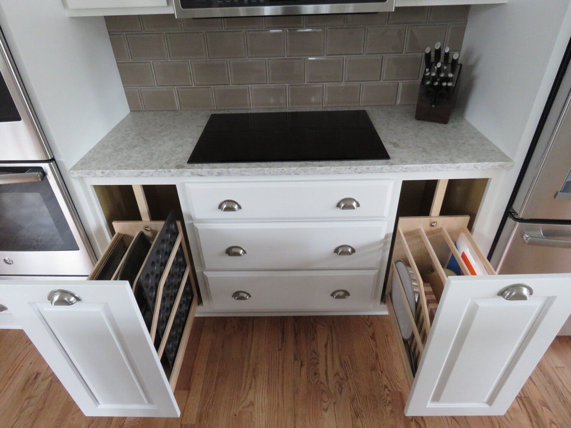 Custom kitchen cabinets with rollout baking sheet organizer.