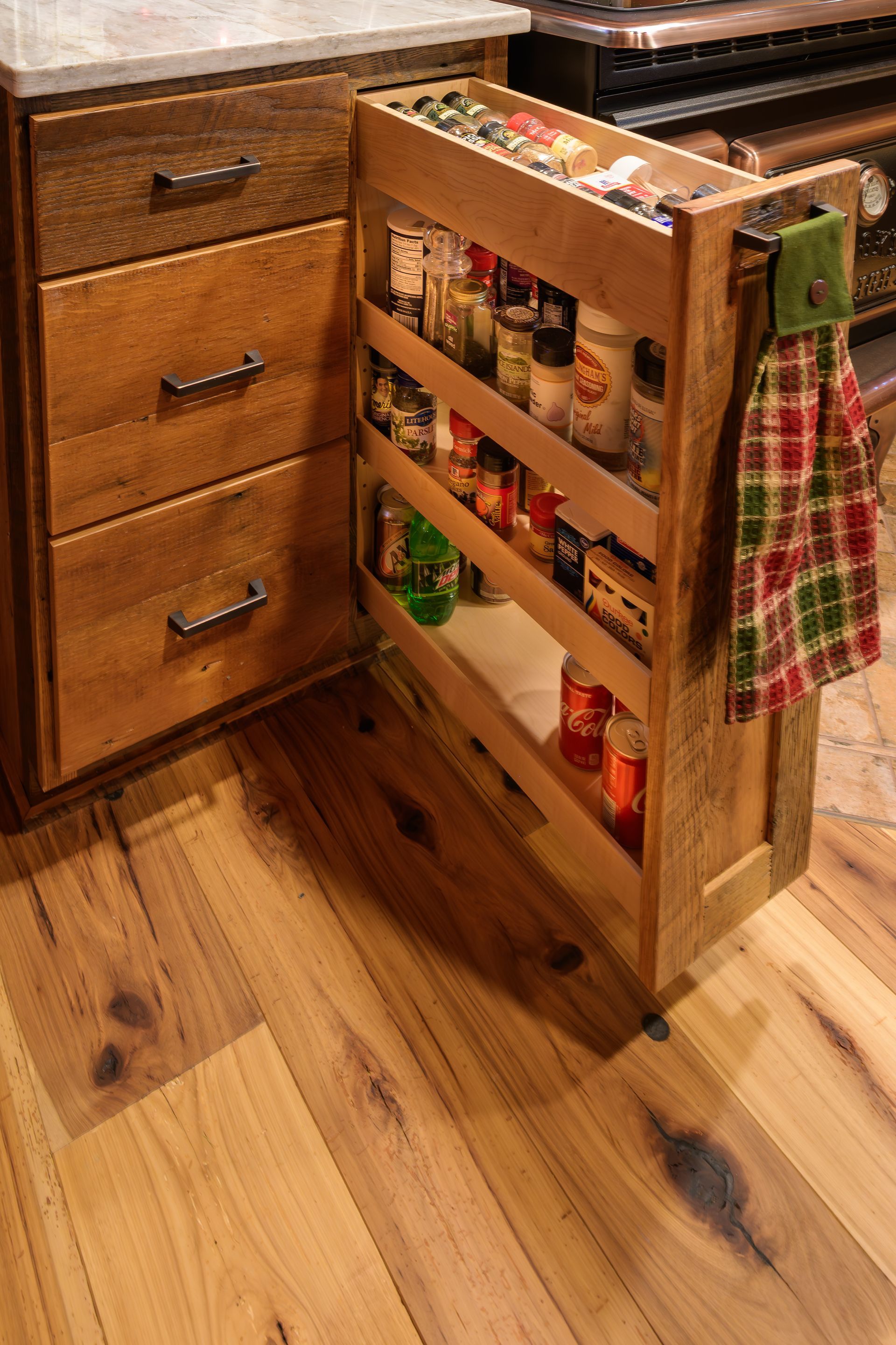 Custom reclaimed barnwood kitchen cabinets with spice rack base cabinet pullout.