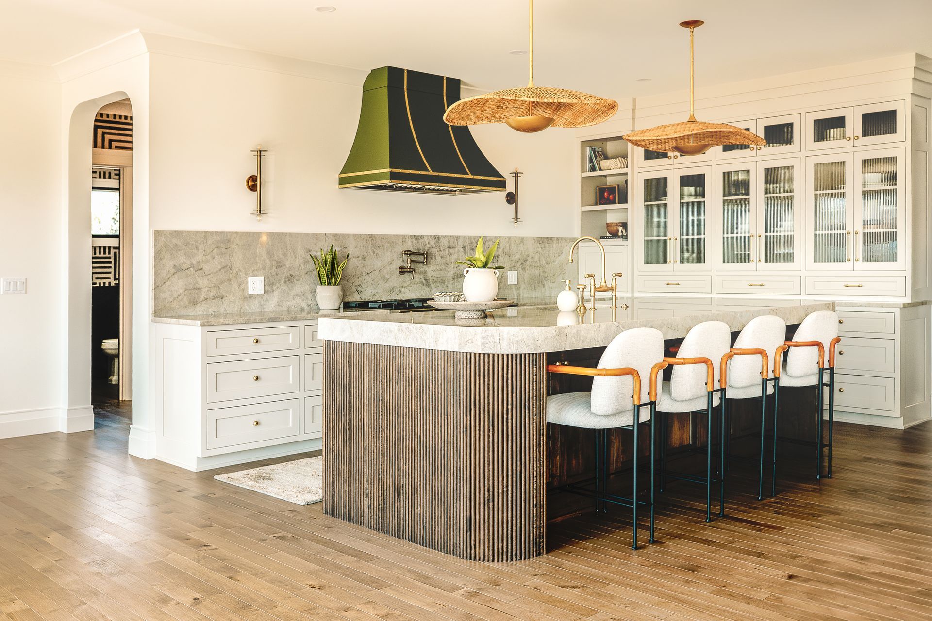 Custom kitchen cabinets painted white for a modern look, curved reeded island and Aisian style pendant lights.
