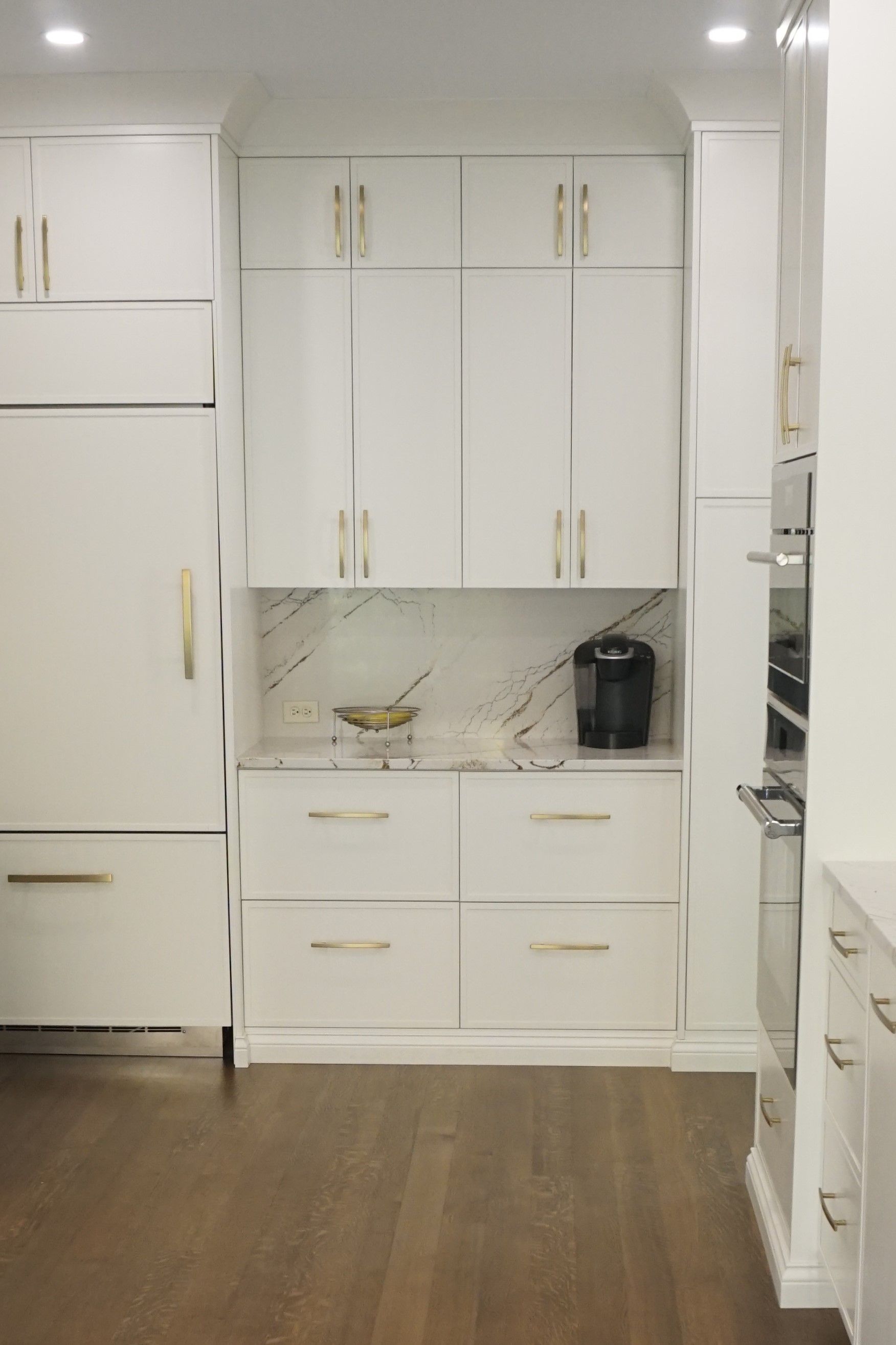 Custom white painted wood modern look kitchen and beverage center cabinets.