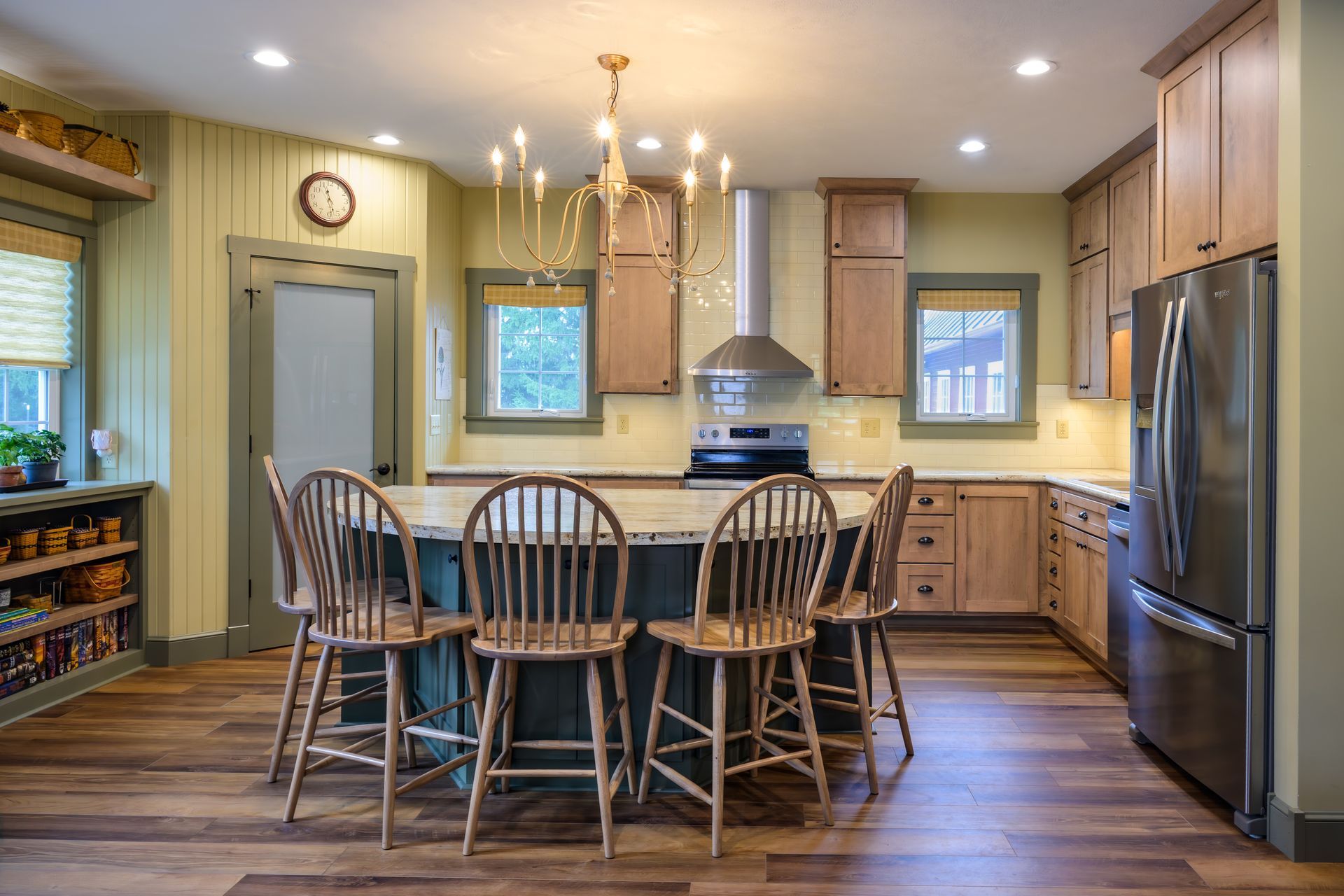 Custom, stained modern wood kitchen cabinets and island, stainless appliances and range hood.