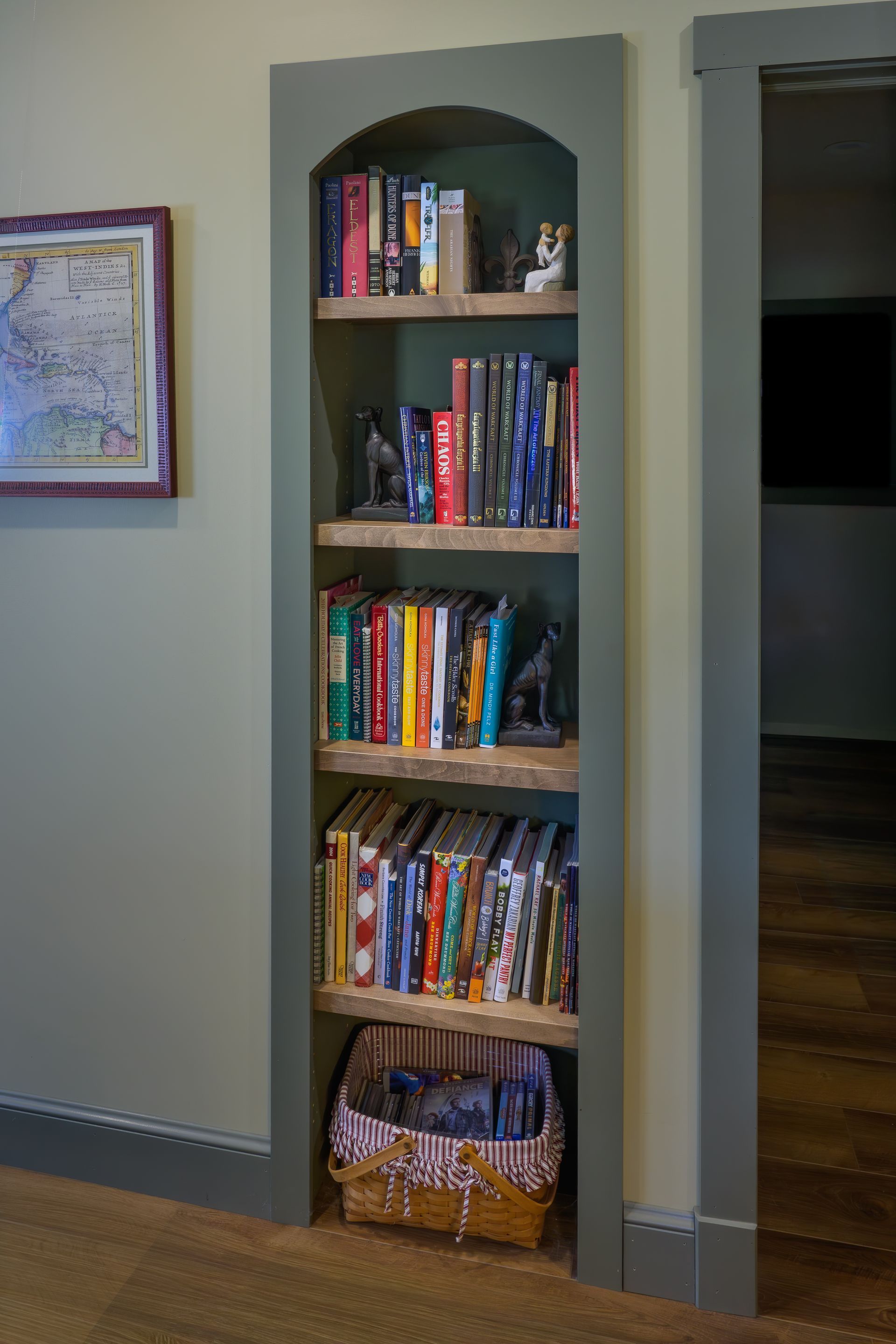 Custom green painted wood built-in bookshelf with arched top.