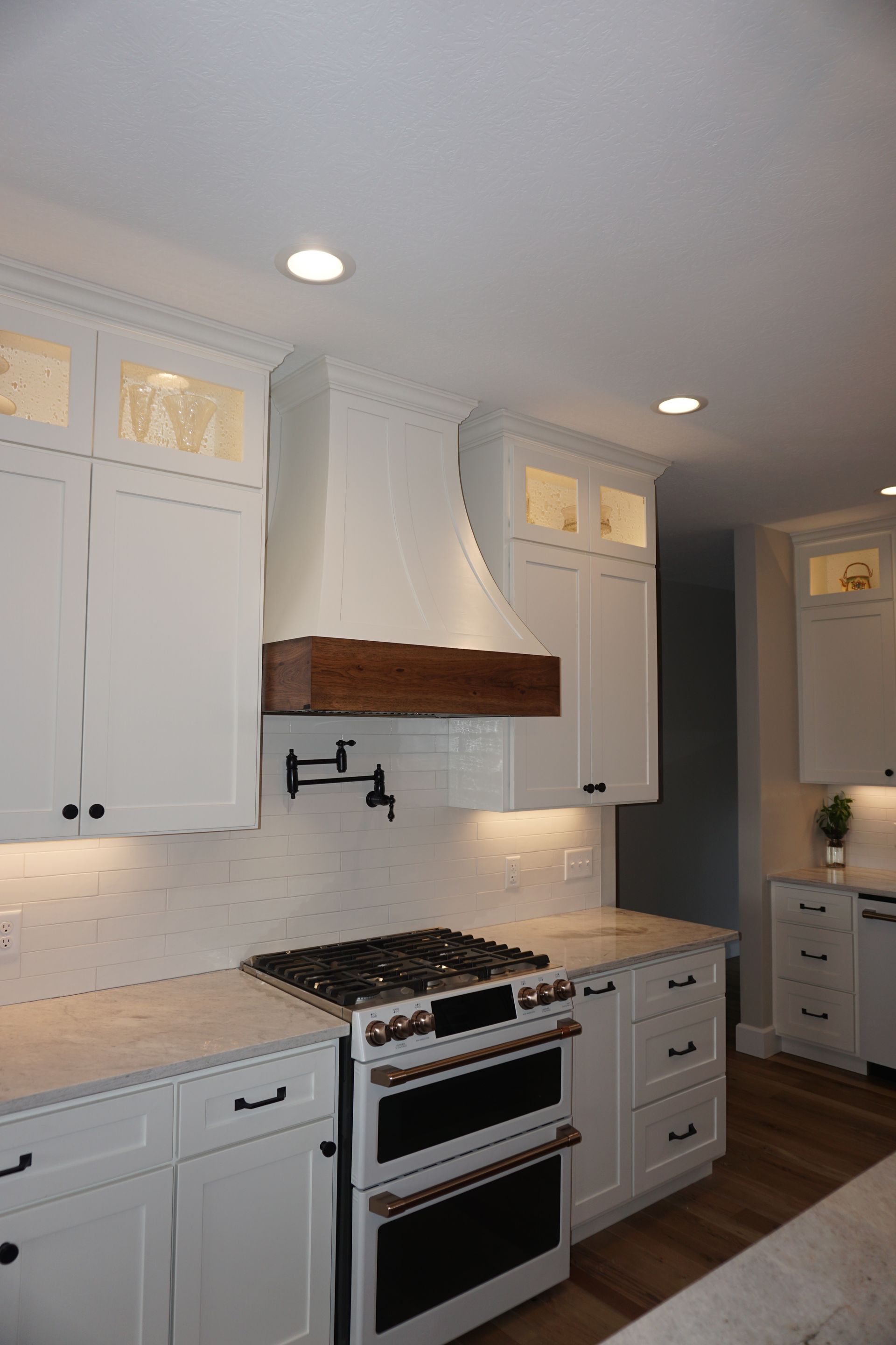Custom white painted and stained wood curved range hood.