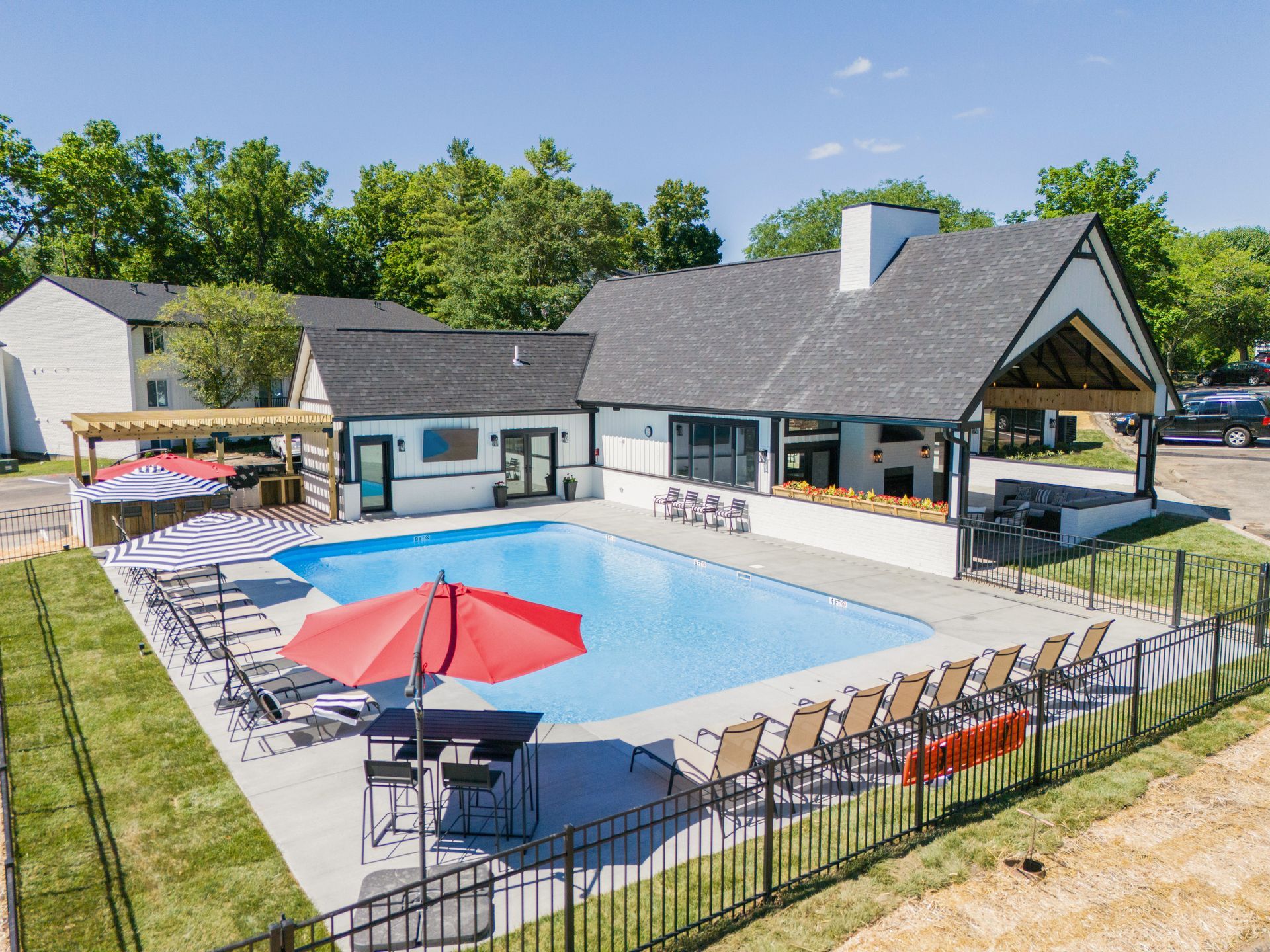 An aerial view of a large swimming pool surrounded by chairs and umbrellas.