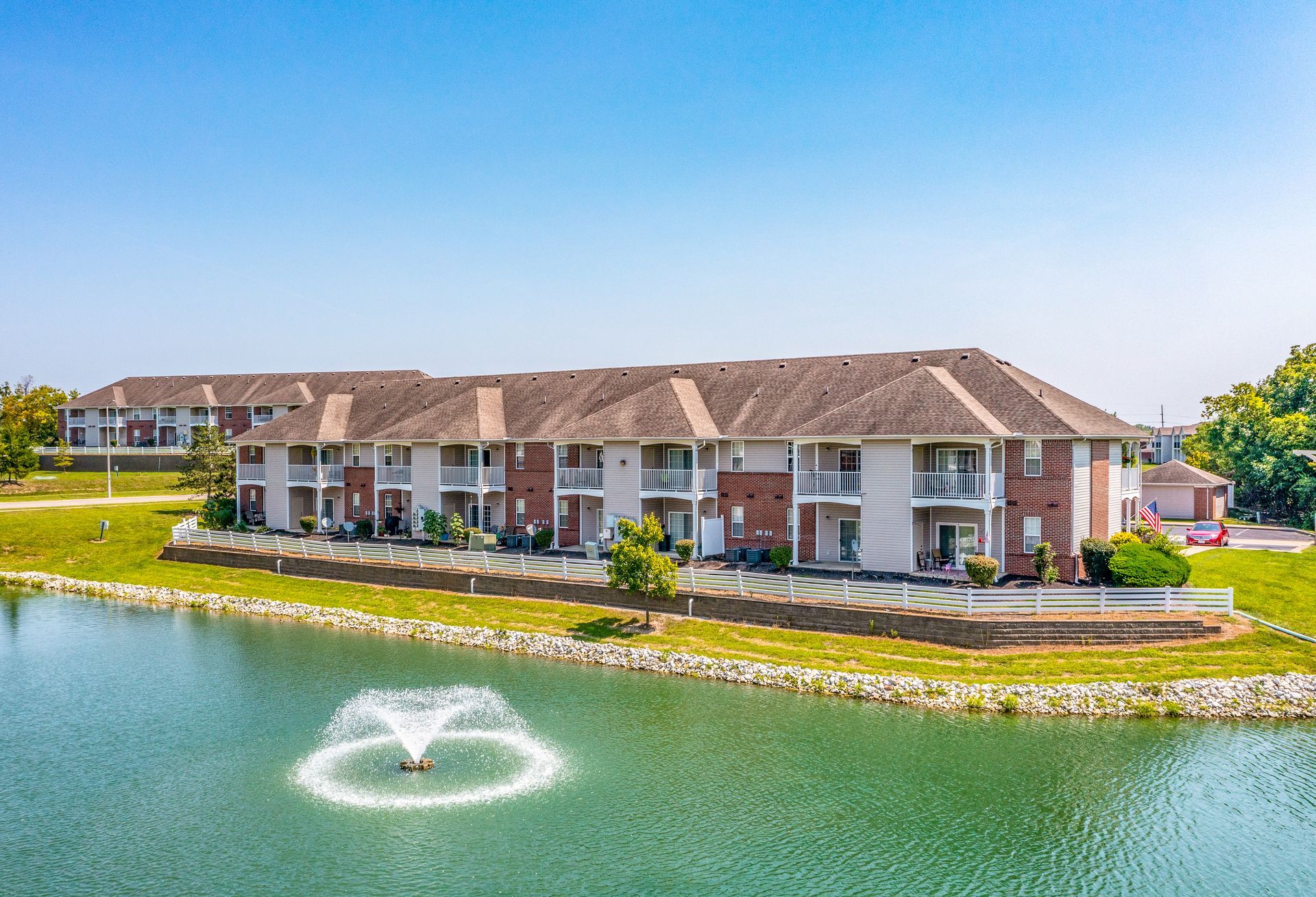 An aerial view of a large apartment building next to a lake.
