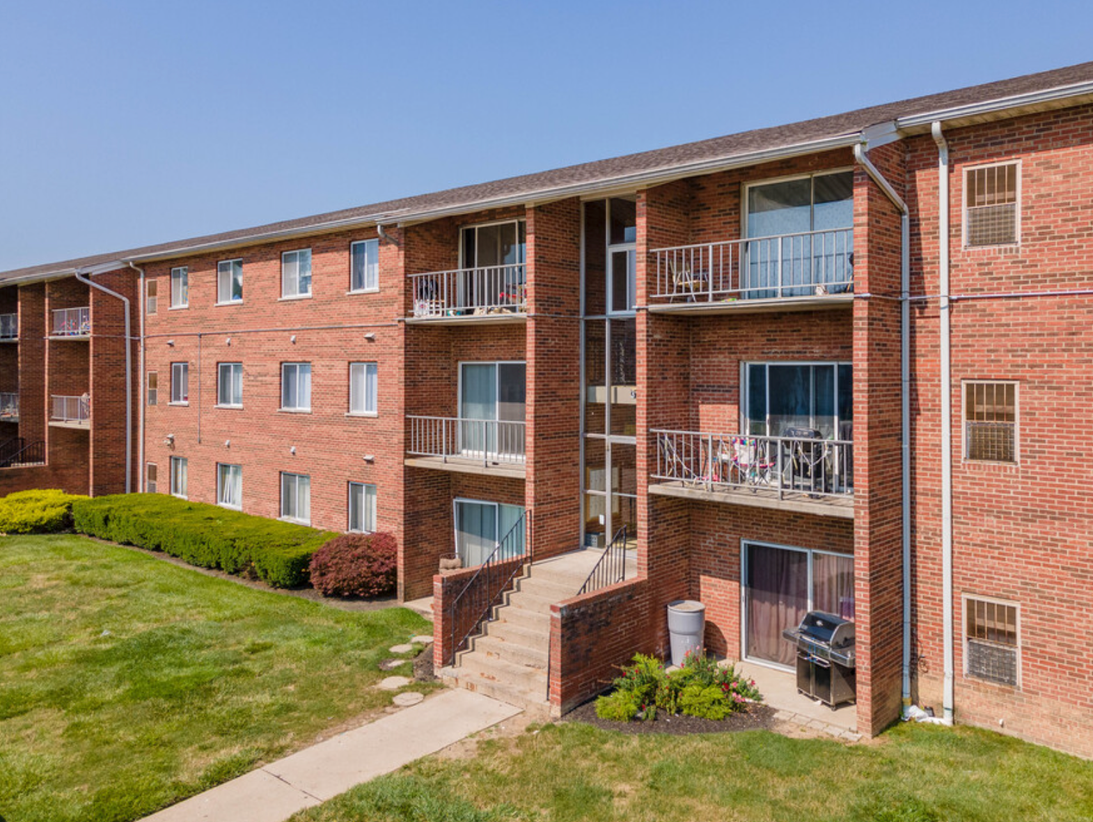 An aerial view of a large brick apartment building with balconies and stairs.