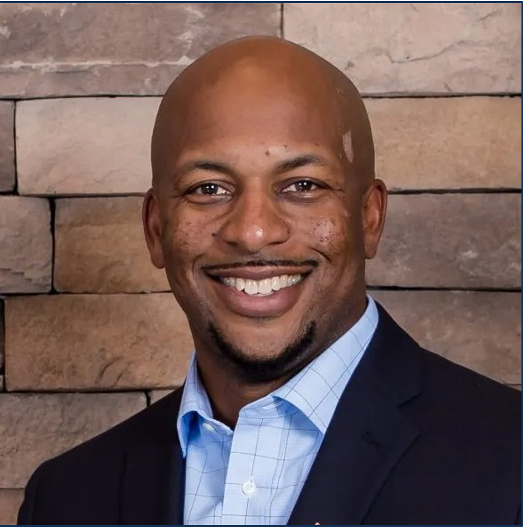 A man in a suit is sitting on a bench in front of a venture real estate co. sign.