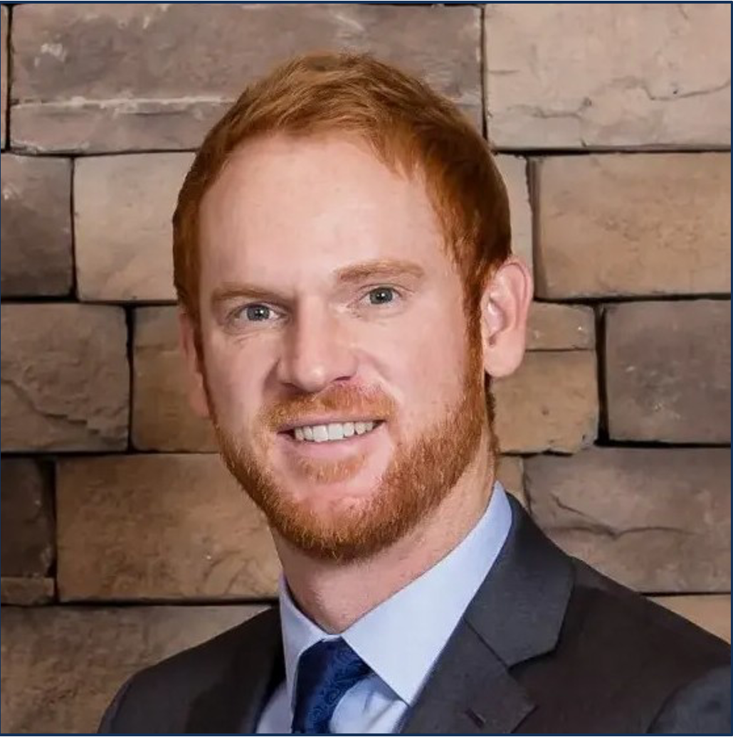 A man in a suit and tie is sitting in front of a venture real estate company sign