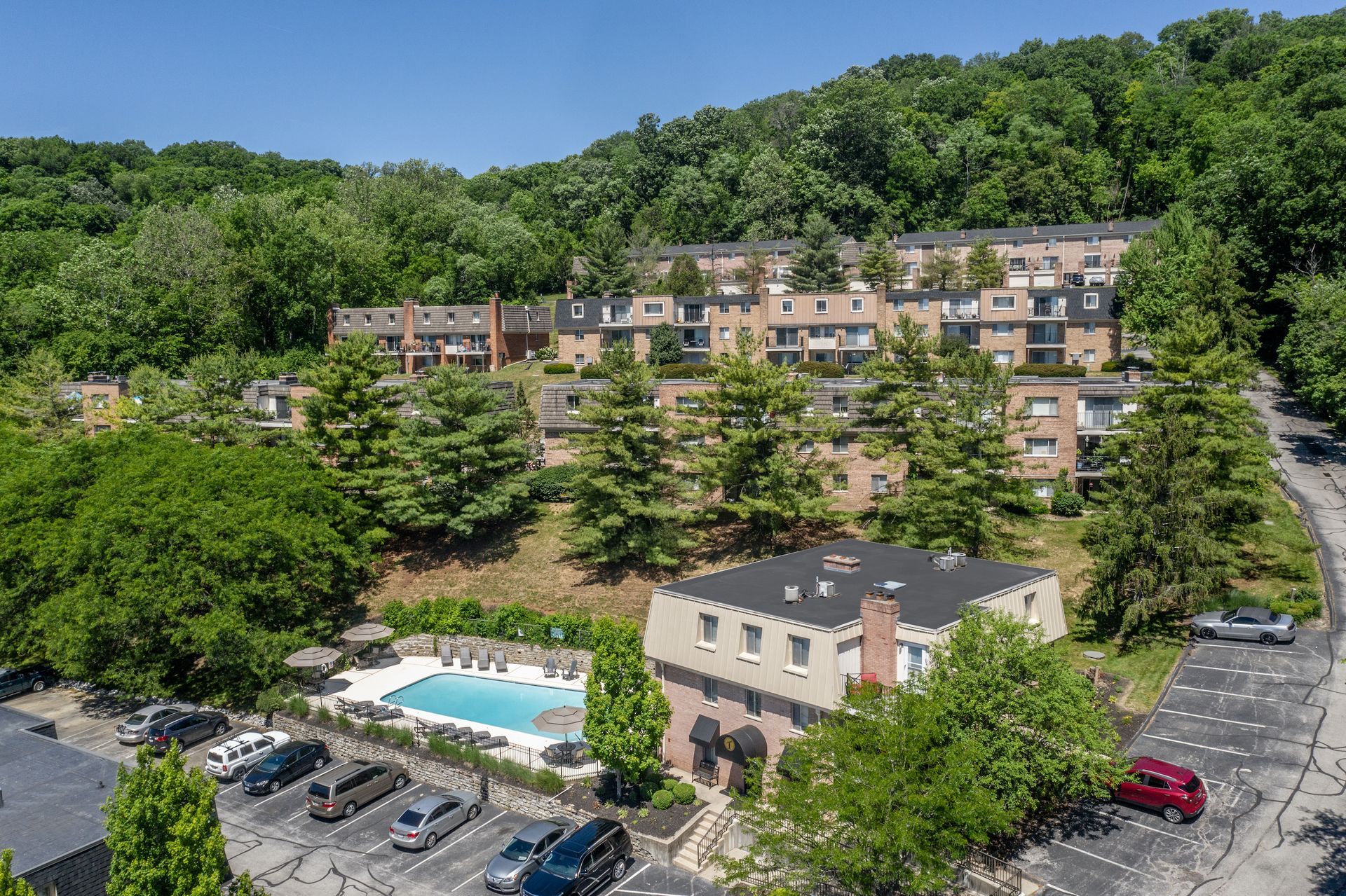 An aerial view of a building with a pool in front of it