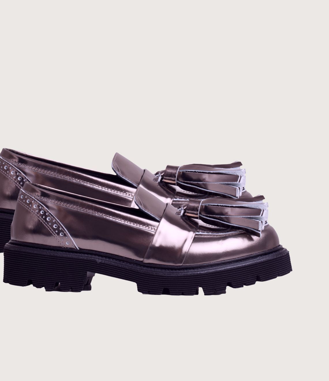 Metallic silver loafer with a tassel, thick black sole.