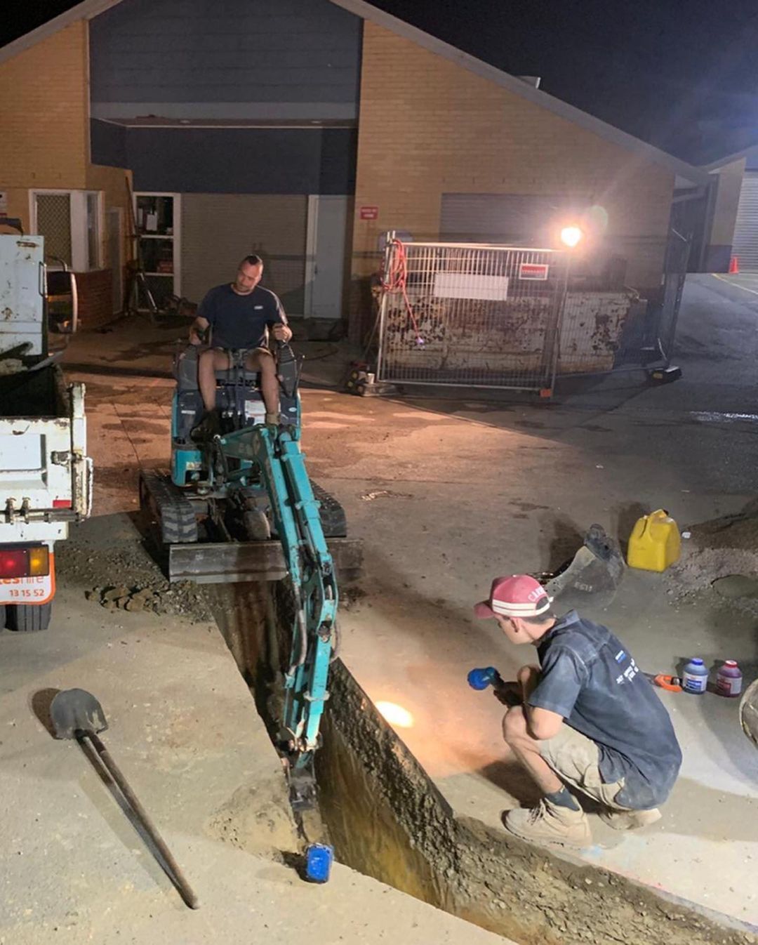 Two men are working on an emergency construction site at night.