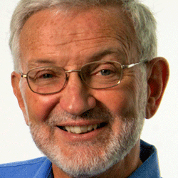 A man with glasses and a beard is smiling for the camera.