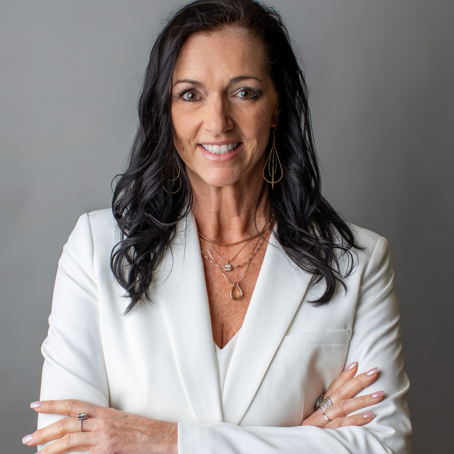 Diane Bevan wearing a black jacket and a blue and white shirt is smiling for the camera.