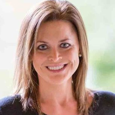 A woman is smiling for the camera and wearing a black shirt.