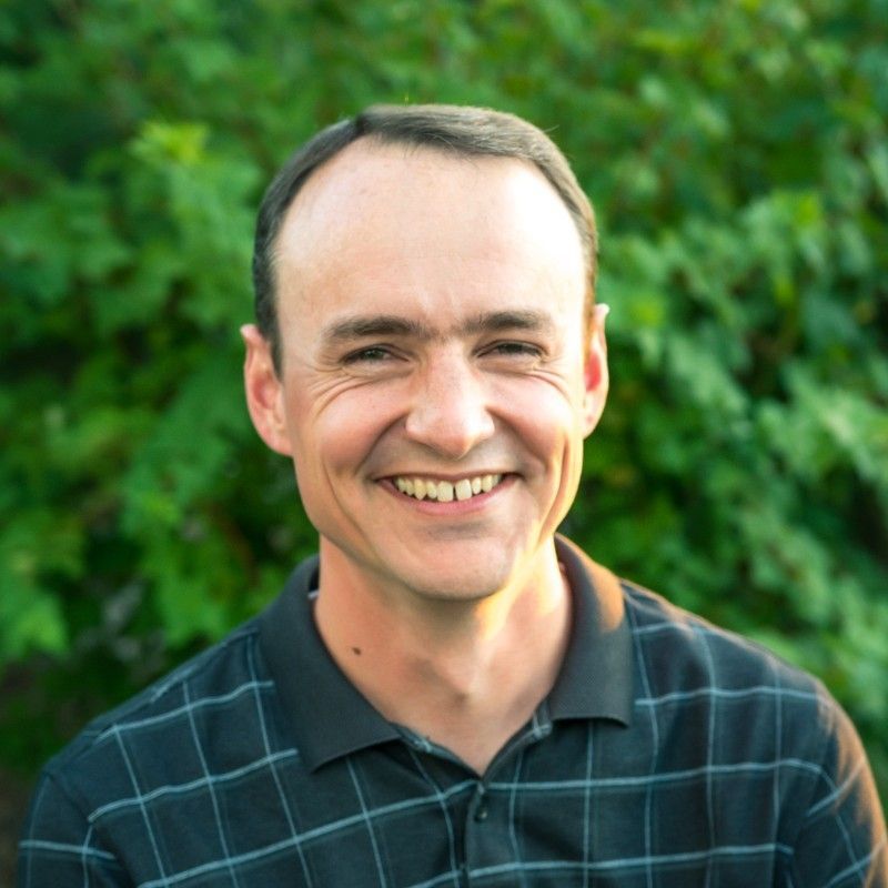 A man in a suit and tie is smiling for the camera.