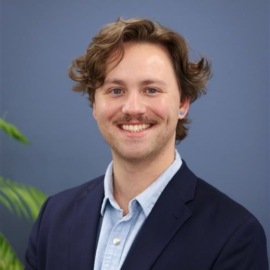 A man with a beard and glasses is smiling for the camera.