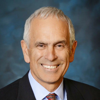 A man in a suit and tie is smiling for the camera.