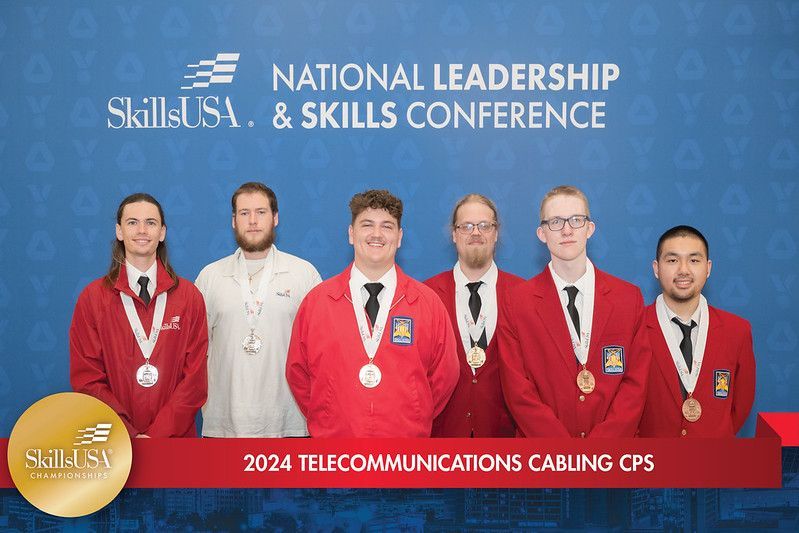 A group of men are posing for a picture at the national leadership and skills conference.