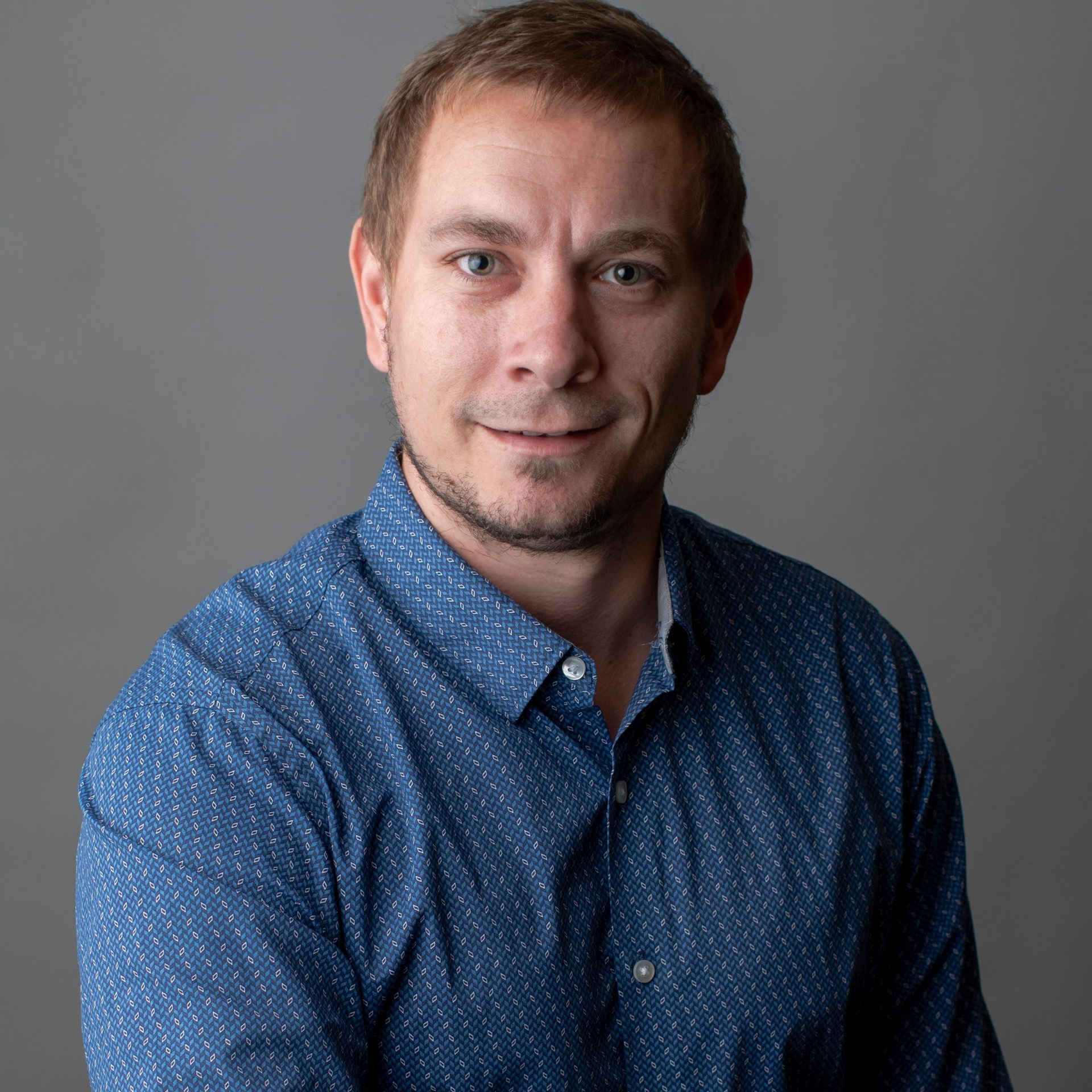 Diane Bevan wearing a black jacket and a blue and white shirt is smiling for the camera.