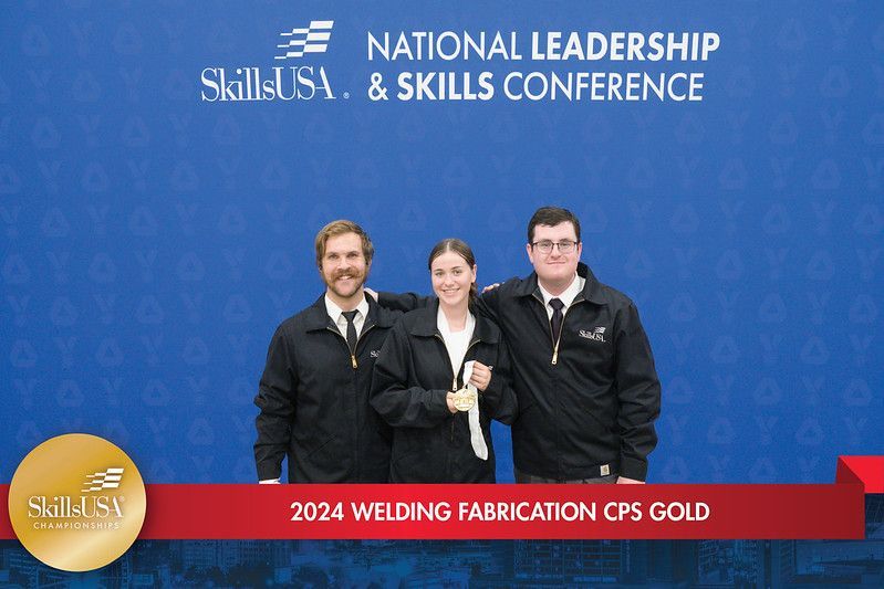 A group of people are posing for a picture in front of a blue background that says national leadership skills conference