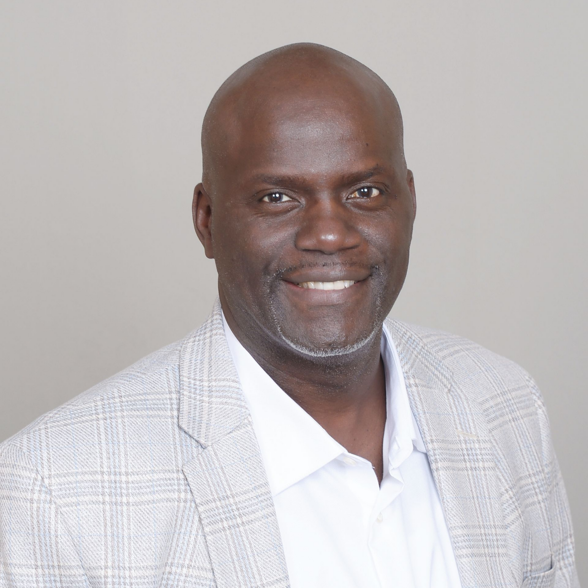 A man in a suit and tie is smiling for the camera
