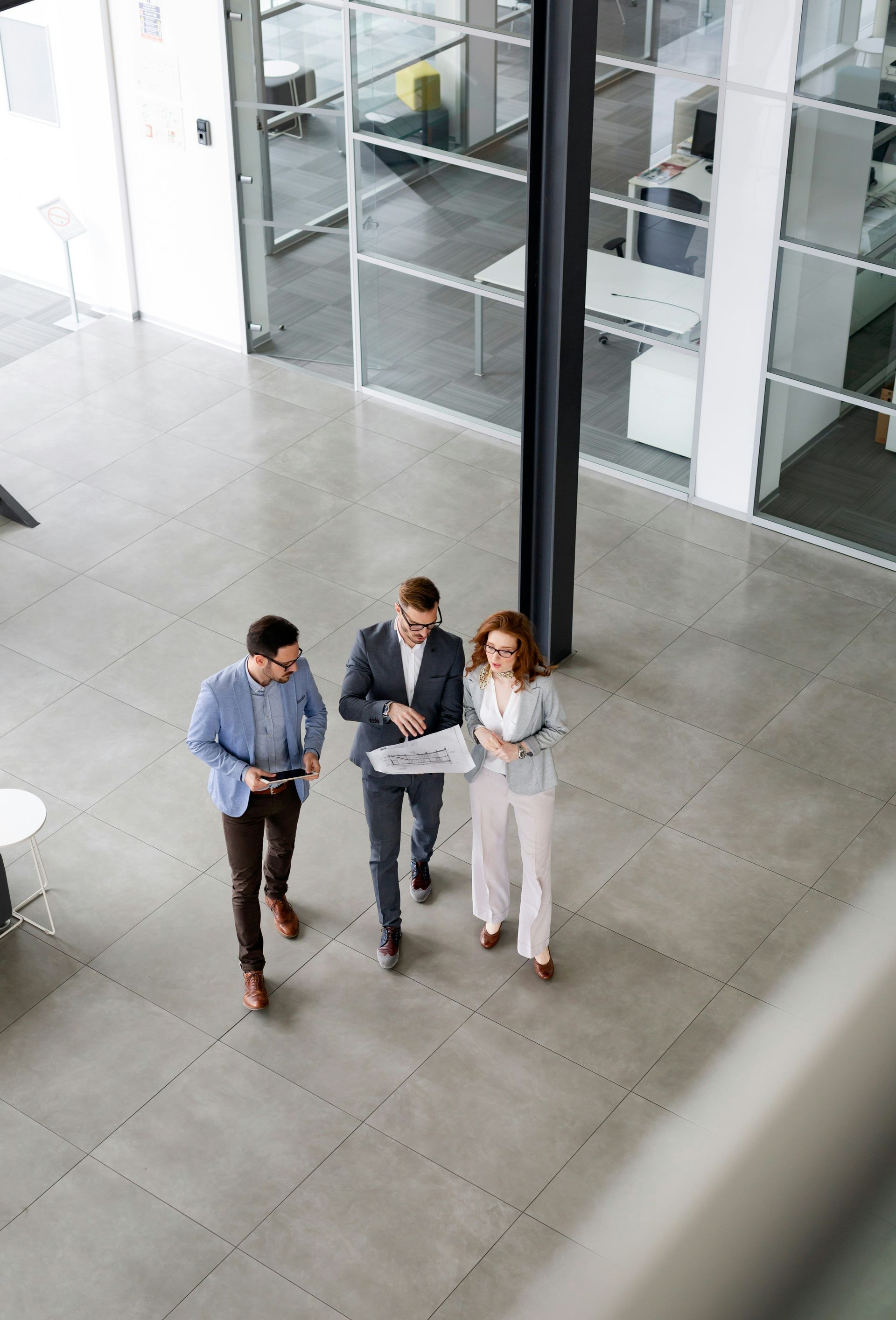A woman is walking down the street holding a cup of coffee.