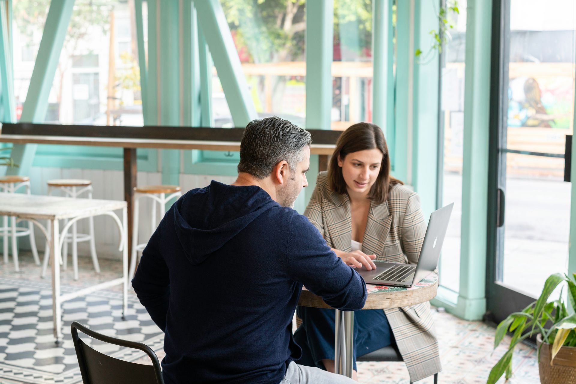 A woman is sitting at a table looking at her cell phone.